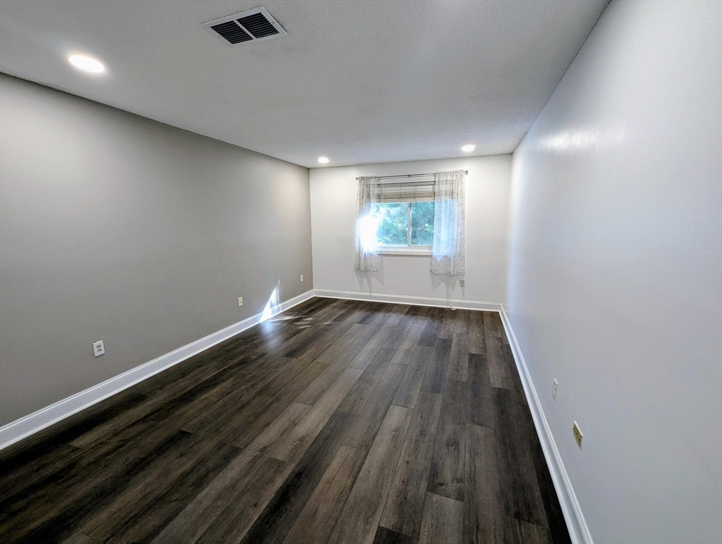 809 Franklin Crossing Road, Unit 809 Franklin, MA 02038 - Photo 12 of 15 an empty room with wooden floor and windows