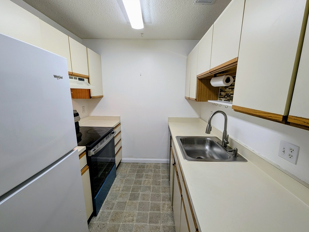 809 Franklin Crossing Road, Unit 809 Franklin, MA 02038 - Photo 5 of 15 a kitchen with a sink and a stove top oven