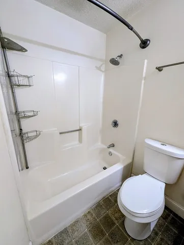 a white bath tub sitting next to a white toilet and sink