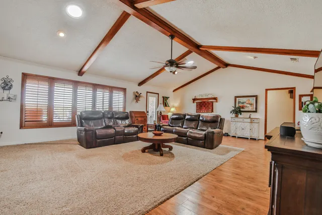 a living room with furniture and a wooden floor