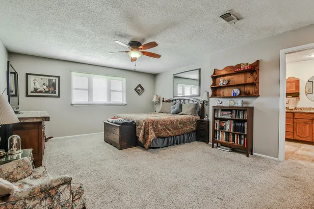 a bedroom with a large bed and a chandelier