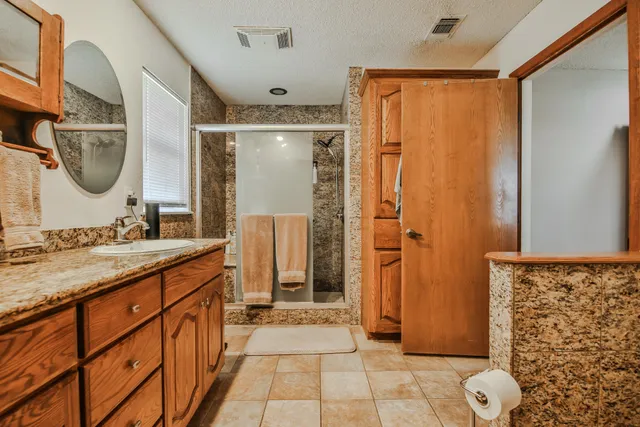 a spacious bathroom with a mirror a sink and a shower