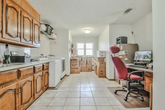 a open kitchen with cabinets a sink and a stove top oven with wooden floor