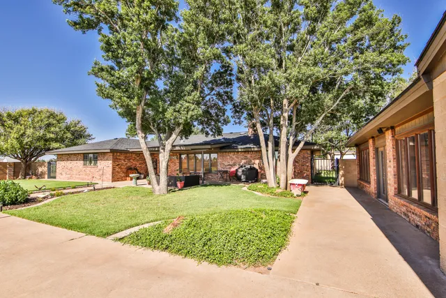 a front view of a house with a yard and trees