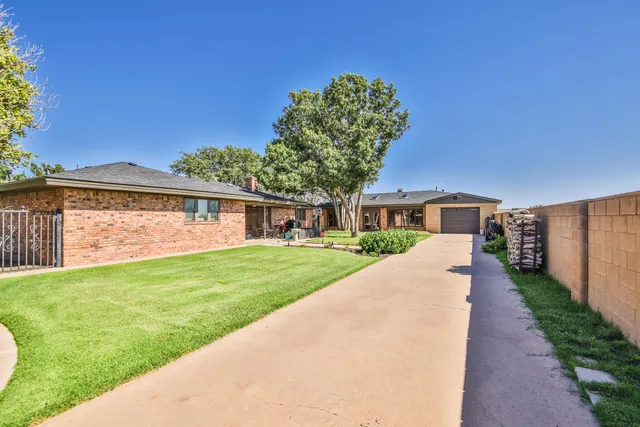 a front view of a house with a garden and yard