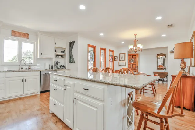 a kitchen with granite countertop white cabinets and chairs