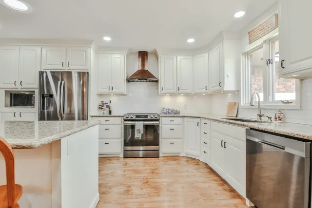a kitchen with granite countertop a sink stove and refrigerator