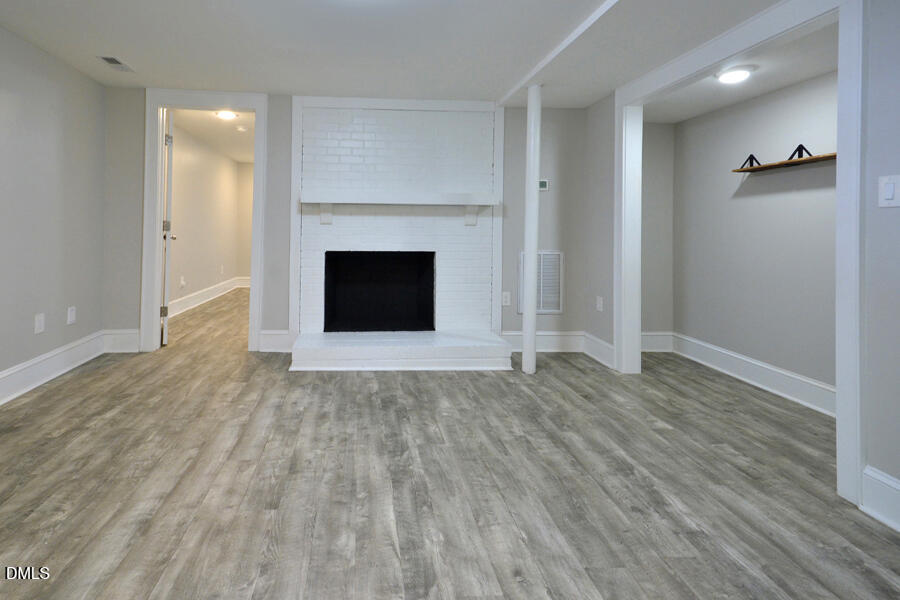 1900 Sunset Avenue Durham, NC 27705 - Photo 11 of 15 an empty room with wooden floor and fireplace