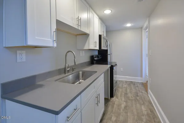 a kitchen with sink a microwave and cabinets