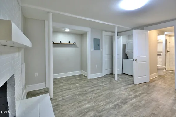 an empty room with wooden floor and fireplace