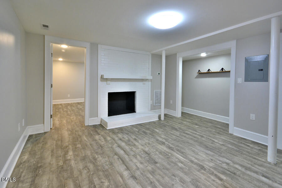 1900 Sunset Avenue Durham, NC 27705 - Photo 6 of 15 an empty room with wooden floor and fireplace