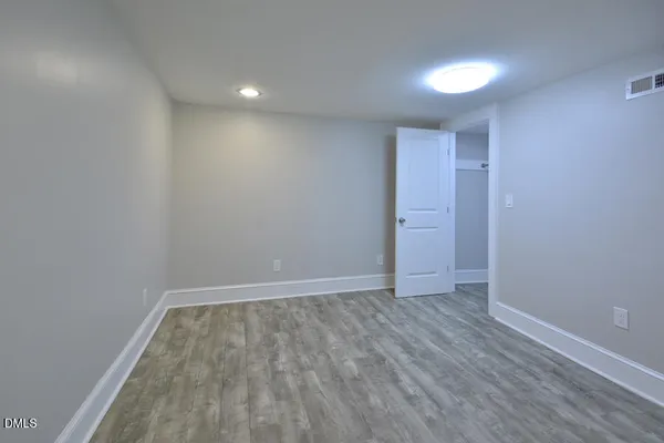 an empty room with wooden floor and fireplace