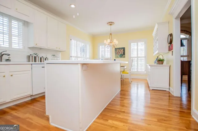 a large kitchen with cabinets wooden floor and stainless steel appliances