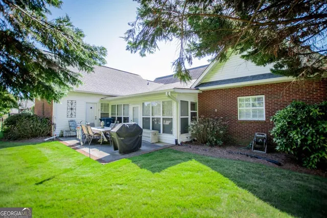 a view of a house with backyard and sitting area