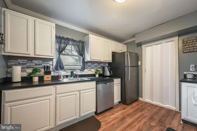 a kitchen with stainless steel appliances granite countertop a stove a sink dishwasher and a refrigerator