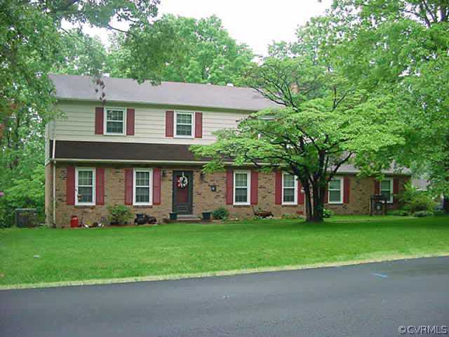 11000 Surry Road Chester, VA 23831 - Photo 1 of 10 a front view of a house with a garden and trees