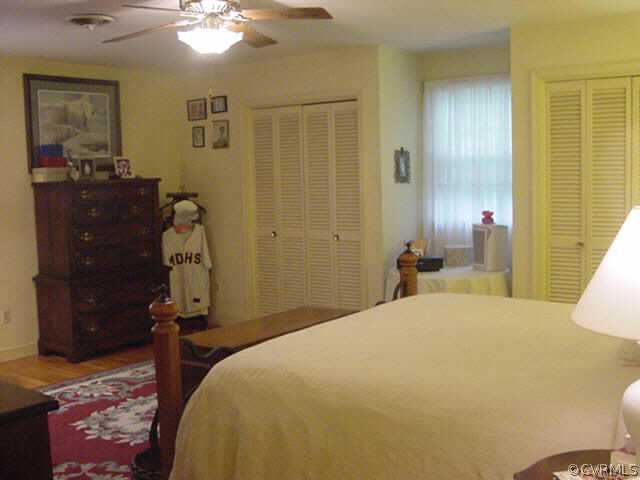11000 Surry Road Chester, VA 23831 - Photo 10 of 10 a bedroom with a bed and wooden floor