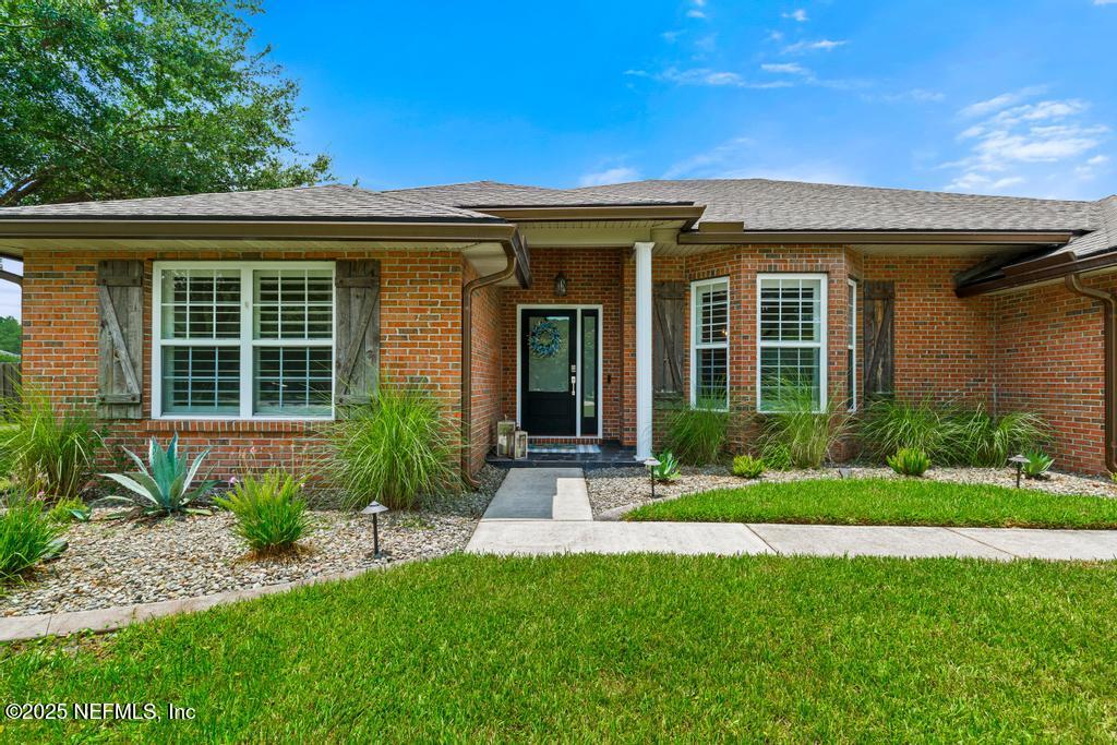 44677 Green Meadows Lane Callahan, FL 32011 - Photo 14 of 91 a front view of a house with a yard and plants