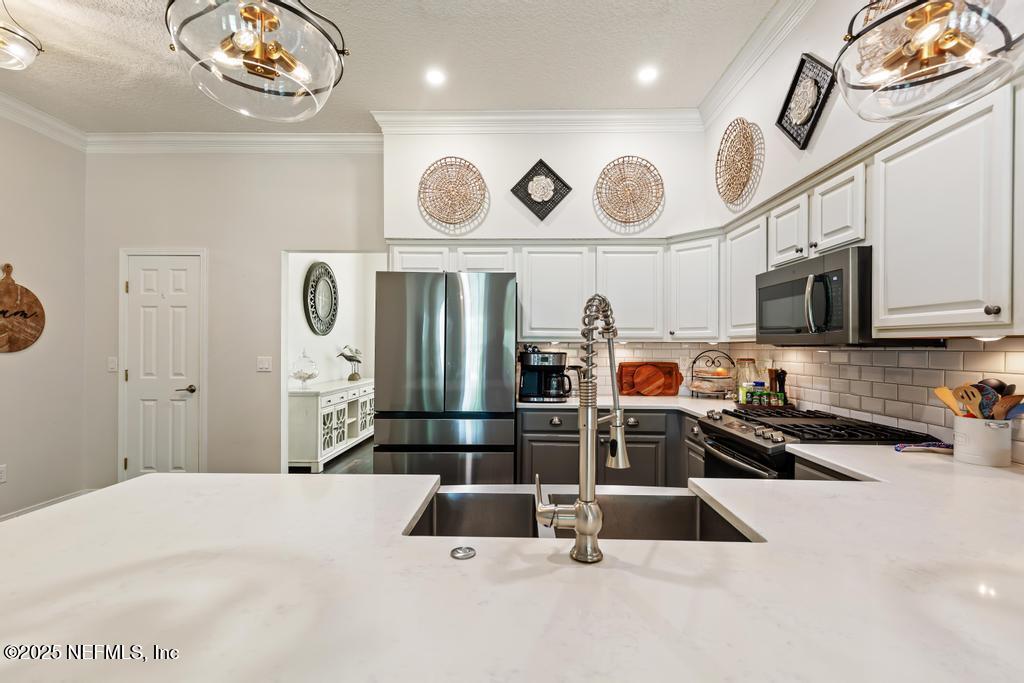 44677 Green Meadows Lane Callahan, FL 32011 - Photo 34 of 91 a kitchen with stainless steel appliances kitchen island granite countertop a sink and cabinets