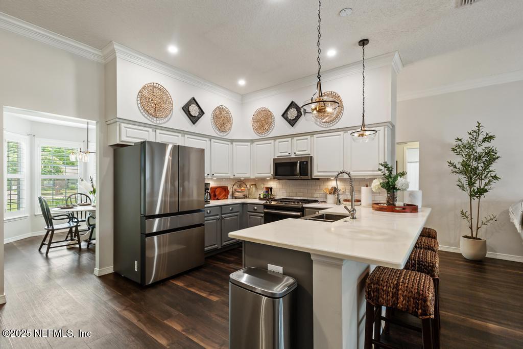 44677 Green Meadows Lane Callahan, FL 32011 - Photo 35 of 91 a kitchen with stainless steel appliances granite countertop a refrigerator a stove a sink and a dining table with chairs
