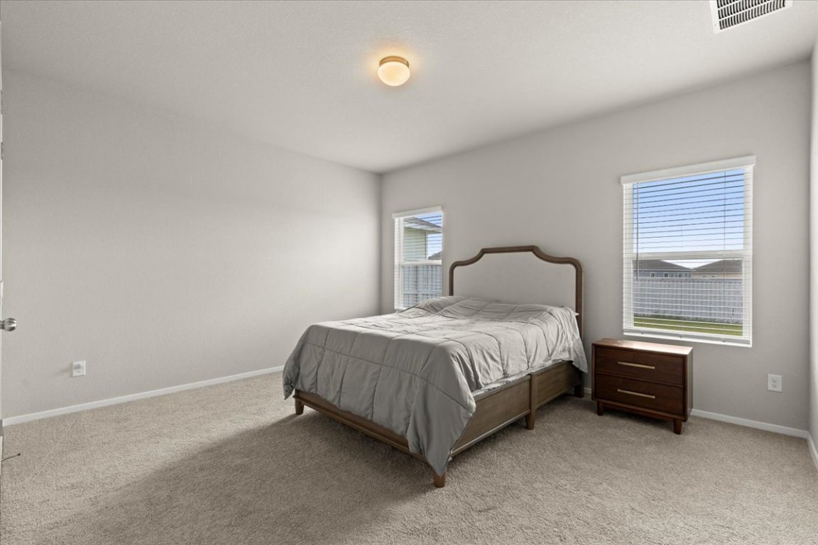 1296 Teychas Drive Kyle, TX 78640 - Photo 14 of 39 a spacious bedroom with a bed and a window