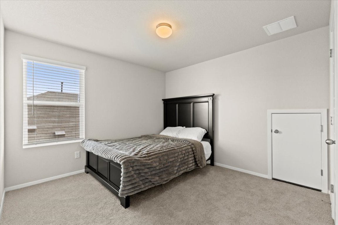 1296 Teychas Drive Kyle, TX 78640 - Photo 23 of 39 a bedroom with a bed and a window