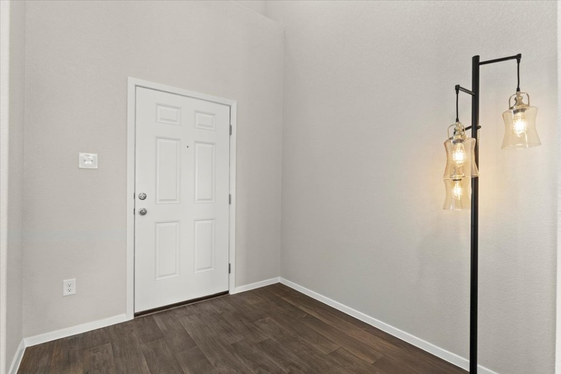 1296 Teychas Drive Kyle, TX 78640 - Photo 7 of 39 Spare room with dark wood-style flooring and baseboards