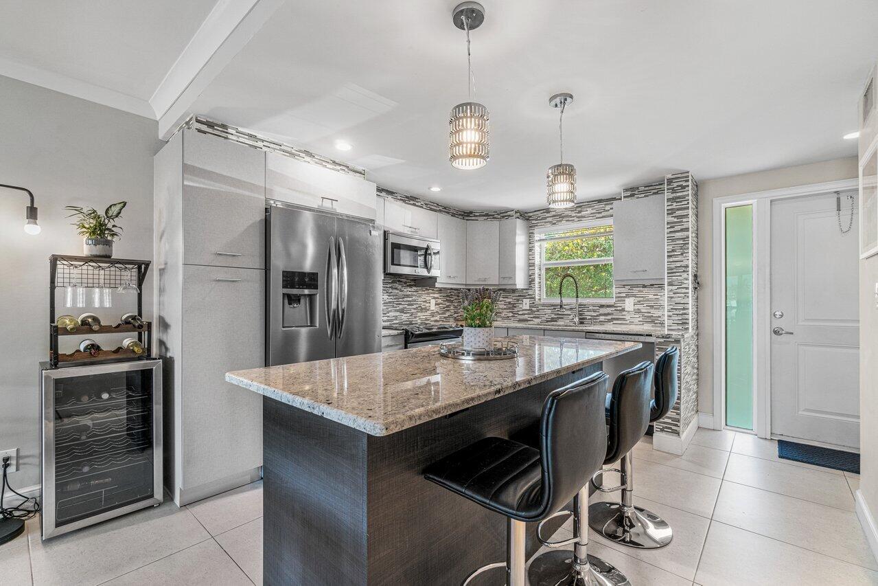 2311 Northeast 36th Street, Unit 1A Lighthouse Point, FL 33064 - Photo 2 of 29 a kitchen with stainless steel appliances granite countertop a stove refrigerator and cabinets