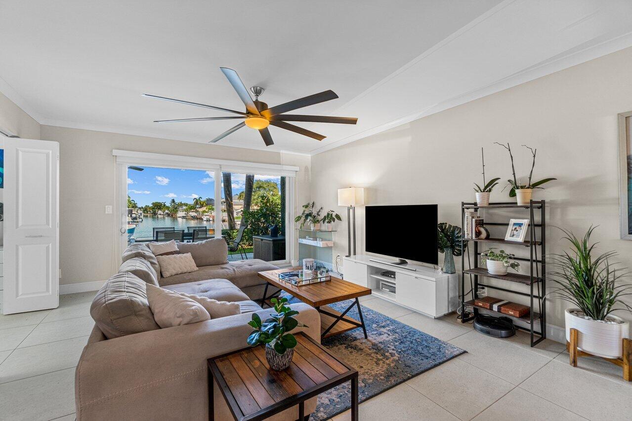 2311 Northeast 36th Street, Unit 1A Lighthouse Point, FL 33064 - Photo 9 of 29 a living room with furniture a chandelier and a flat screen tv