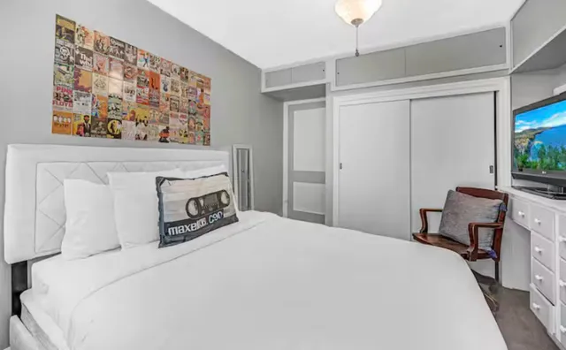 a bedroom with a bed and a flat screen tv