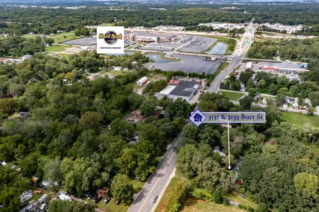 an aerial view of residential houses with outdoor space and trees