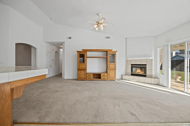 a view of an empty room with a fireplace and a window