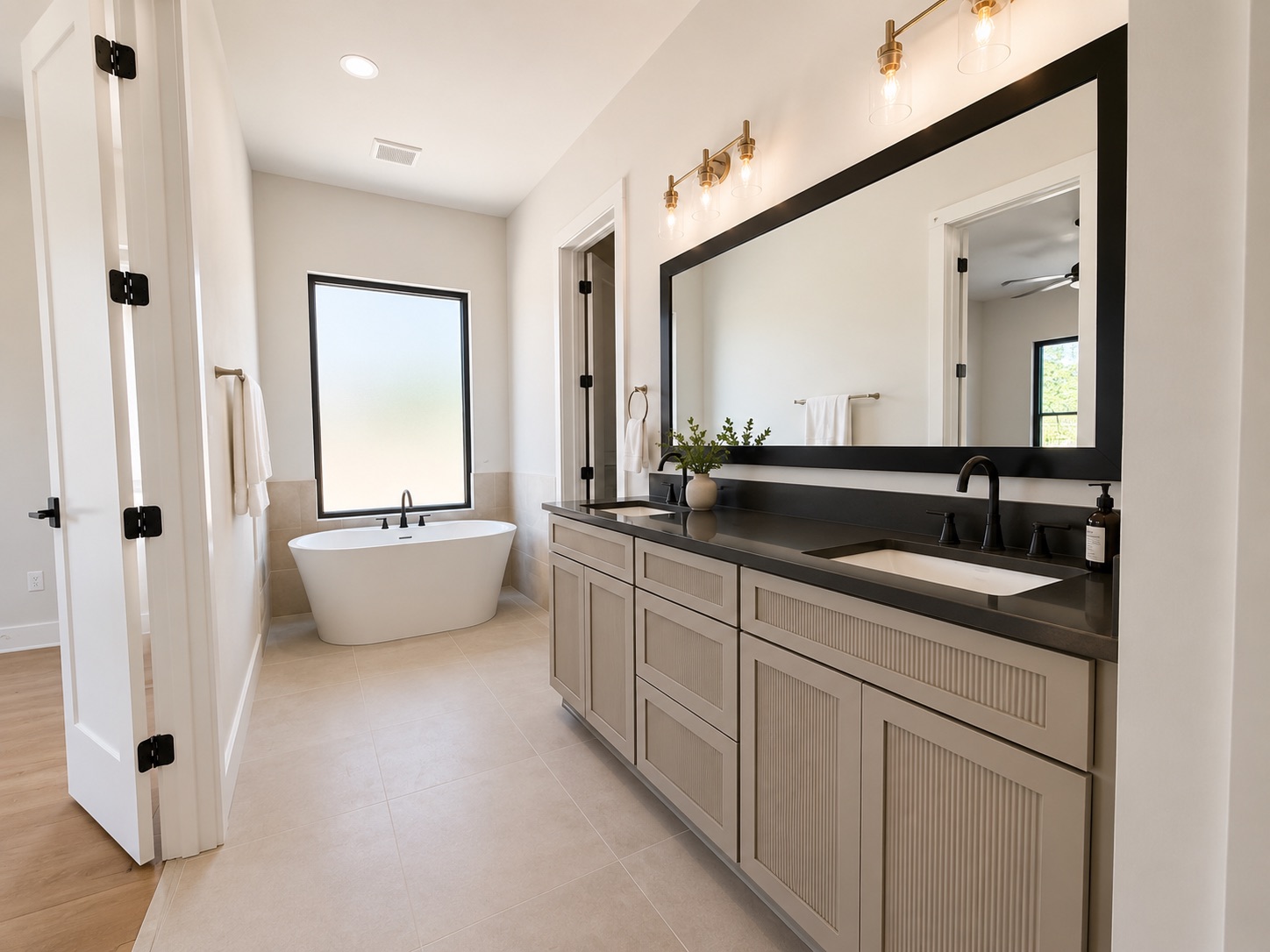 711 Paleface Ranch Road, Unit 4 Spicewood, TX 78669 - Photo 7 of 14 A spacious primary bathroom boasts a freestanding soaking tub and a generous double vanity with a large mirror.