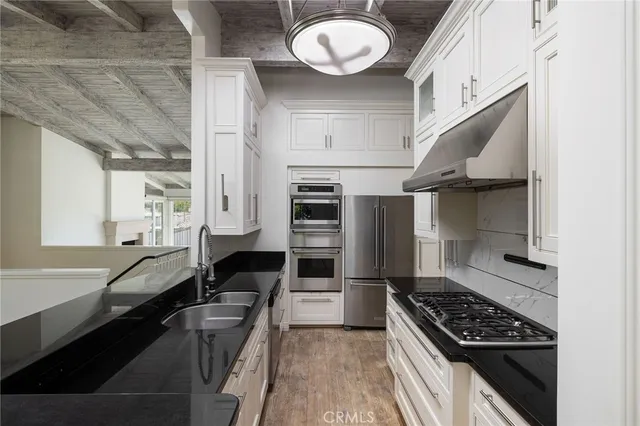 a kitchen with stainless steel appliances a stove a sink and a refrigerator