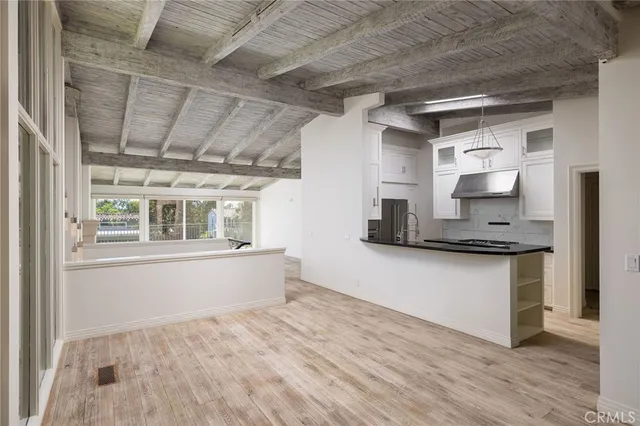 a kitchen with granite countertop a stove and a white cabinets