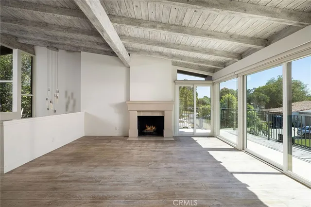 a view of empty room with wooden floor and fireplace