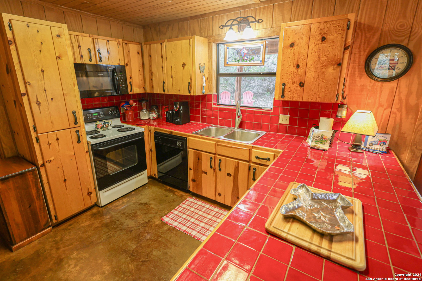 1177 River Road Concan, TX 78838 - Photo 13 of 34 a kitchen with stainless steel appliances granite countertop a stove a sink and a microwave