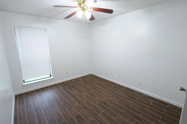 an empty room with wooden floor chandelier fan and closet
