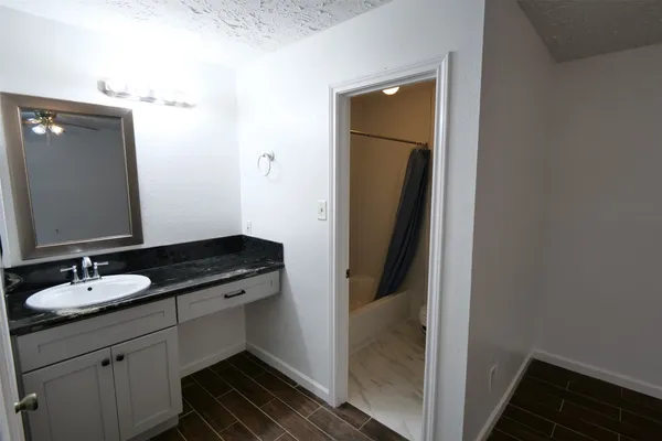 a bathroom with a granite countertop sink and a mirror