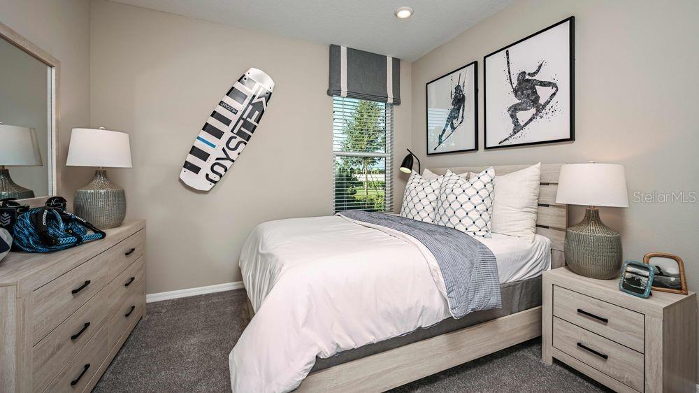6917 Prairie Oak Way Nokomis, FL 34275 - Photo 12 of 28 a bedroom with a bed and a lamp on dresser