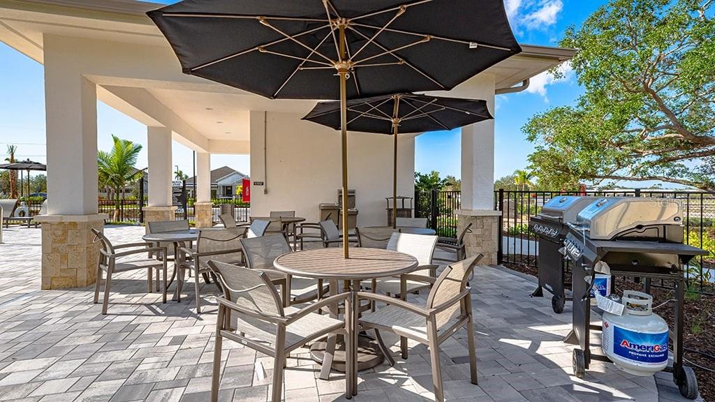 6917 Prairie Oak Way Nokomis, FL 34275 - Photo 26 of 28 a view of a patio with table and chairs under an umbrella