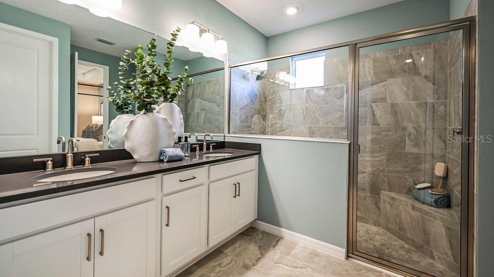 6917 Prairie Oak Way Nokomis, FL 34275 - Photo 9 of 28 a bathroom with a granite countertop sink a mirror and shower