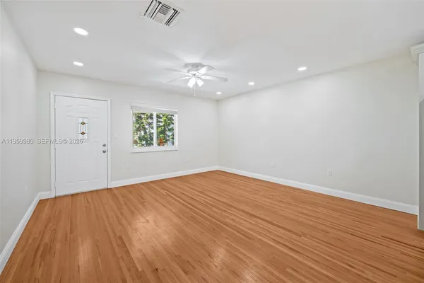 wooden floor in an empty room with a window