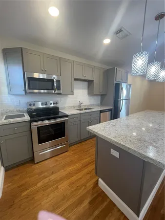 a kitchen with stainless steel appliances granite countertop a stove a sink and a refrigerator
