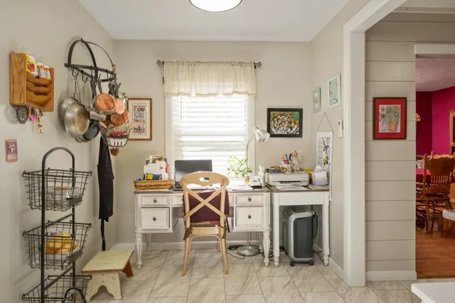 a view of a workspace with furniture and a window