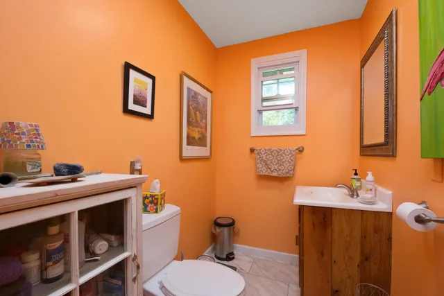 a bathroom with a granite countertop toilet sink and mirror