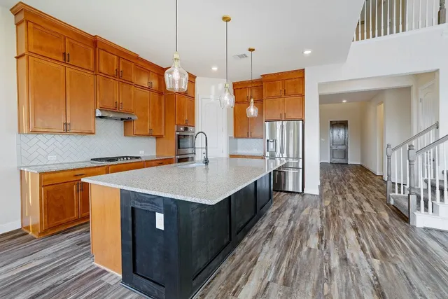 a kitchen with counter top space and wooden floor