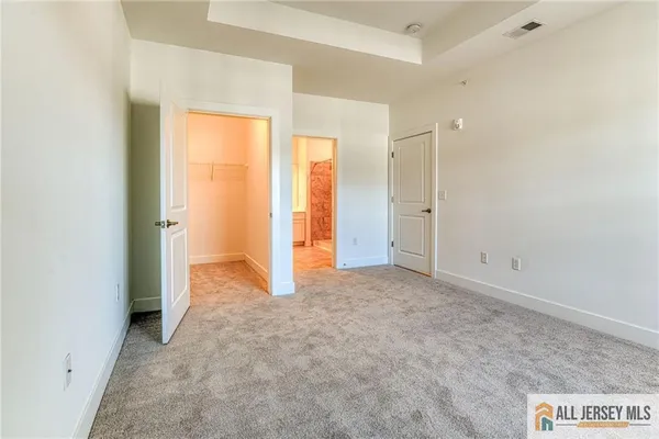 an empty room with closet and a bathroom