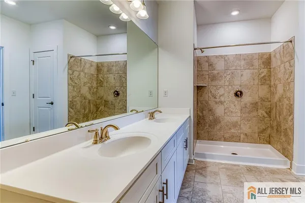 a bathroom with a shower sink and mirror