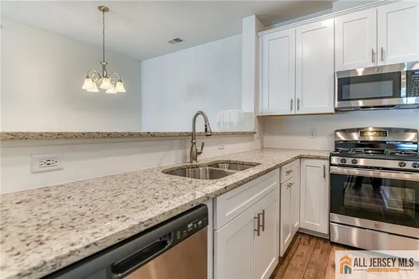a kitchen with granite countertop a sink and a stove